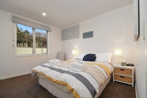 A bedroom with a bed, bedside tables, a window, and a motivational quote on the wall. - Lakefront Oasis - Jetty, Hot Tub & Kayaks (Okere Falls)