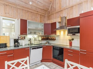 Une cuisine moderne avec des panneaux en bois, des appareils en acier inoxydable et un plan de travail en granit.