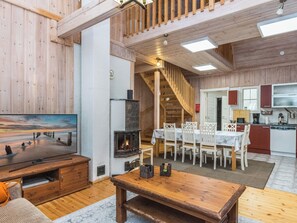 Amplia sala de estar con chimenea, muebles de madera y un televisor.