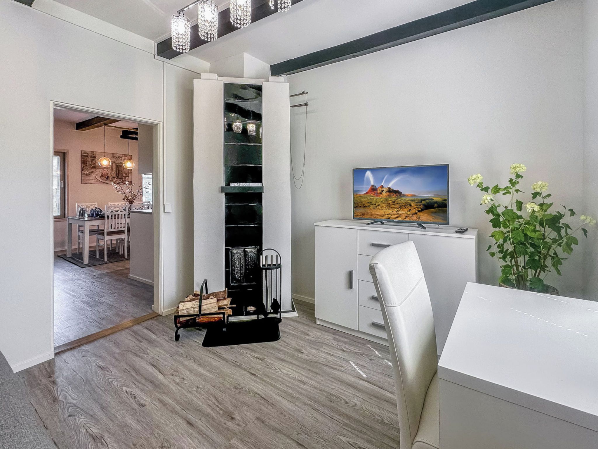 Un interior moderno con comedor, chimenea y televisor.