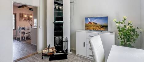 Un interior moderno con comedor, chimenea y televisor.