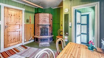 Une pièce avec une cheminée en briques, des portes en bois, une table à manger et un mur vert.