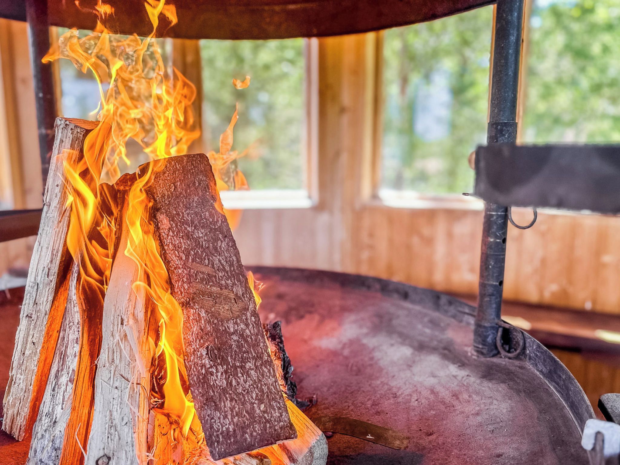 Ein Holzfeuer brennt in einem Kamin mit einem Metallrost.