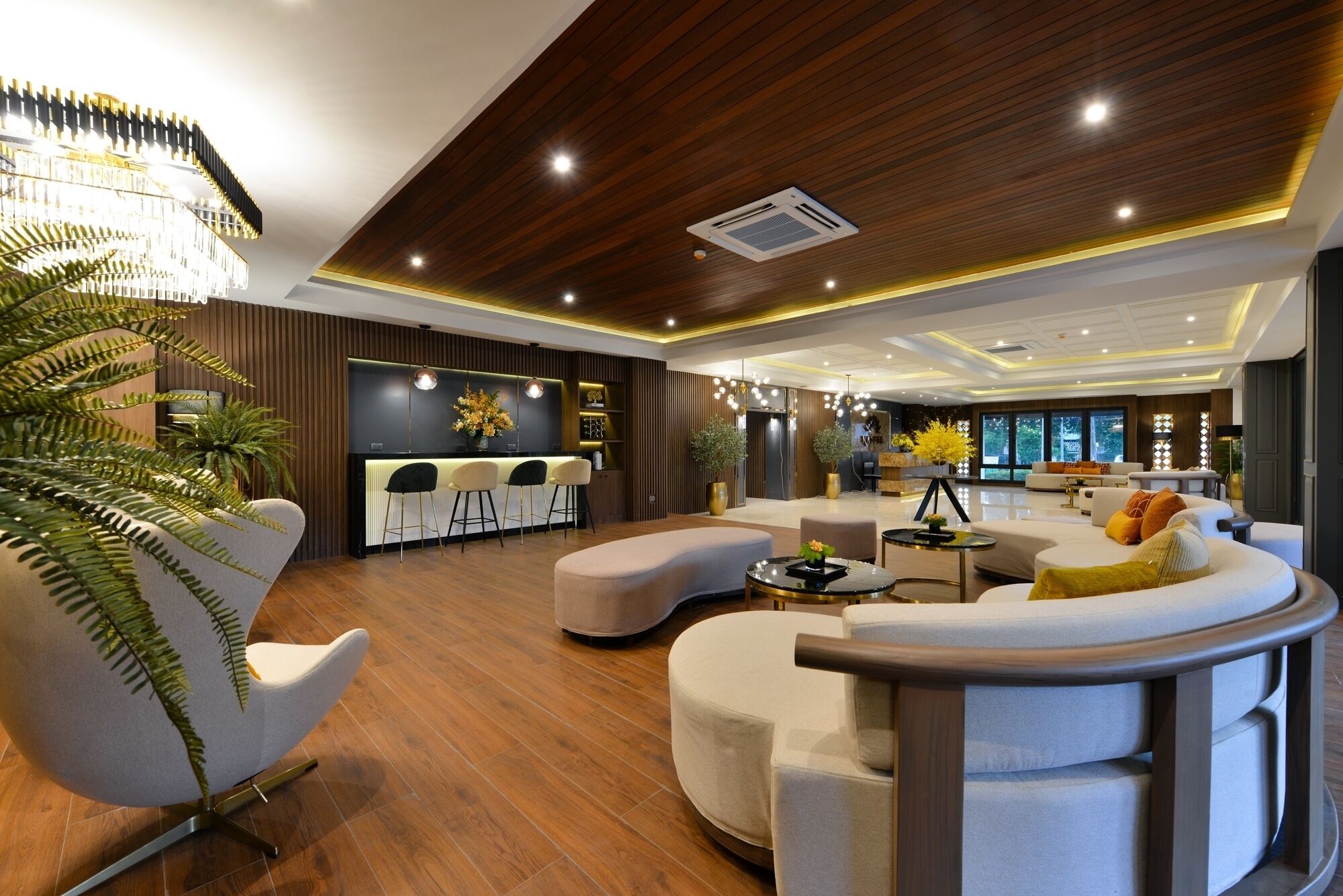 A modern living room with a wooden ceiling, a bar area, and a seating arrangement.