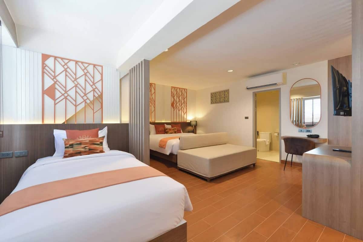 Habitación de hotel con una cama grande, un sofá, un escritorio y un baño.