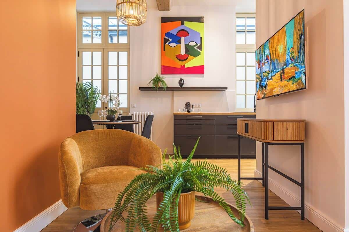 A modern living room with a sofa, a coffee table, and a fern plant.