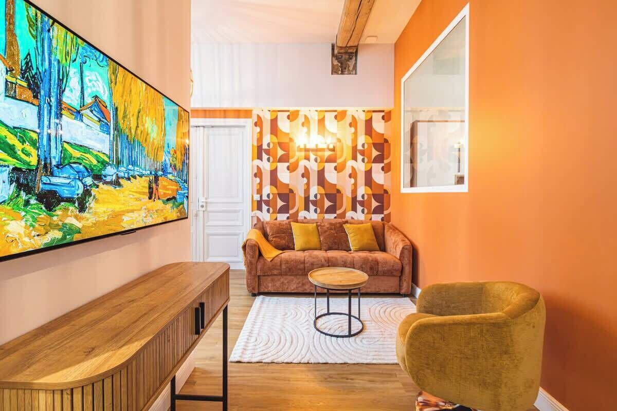 A living room with a large painting, a sofa with cushions, a coffee table, and a chair.