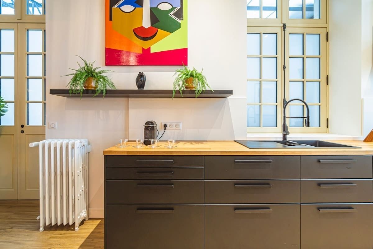 Una cocina moderna con encimera de madera, estufa integrada y un amplio ventanal.