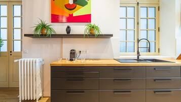 Una cocina moderna con encimera de madera, estufa integrada y un amplio ventanal.