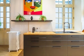 A modern kitchen with a wooden countertop, a built-in stove, and a large window.