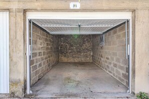 Un garage avec un toit en métal, des murs en briques et un plancher en béton.