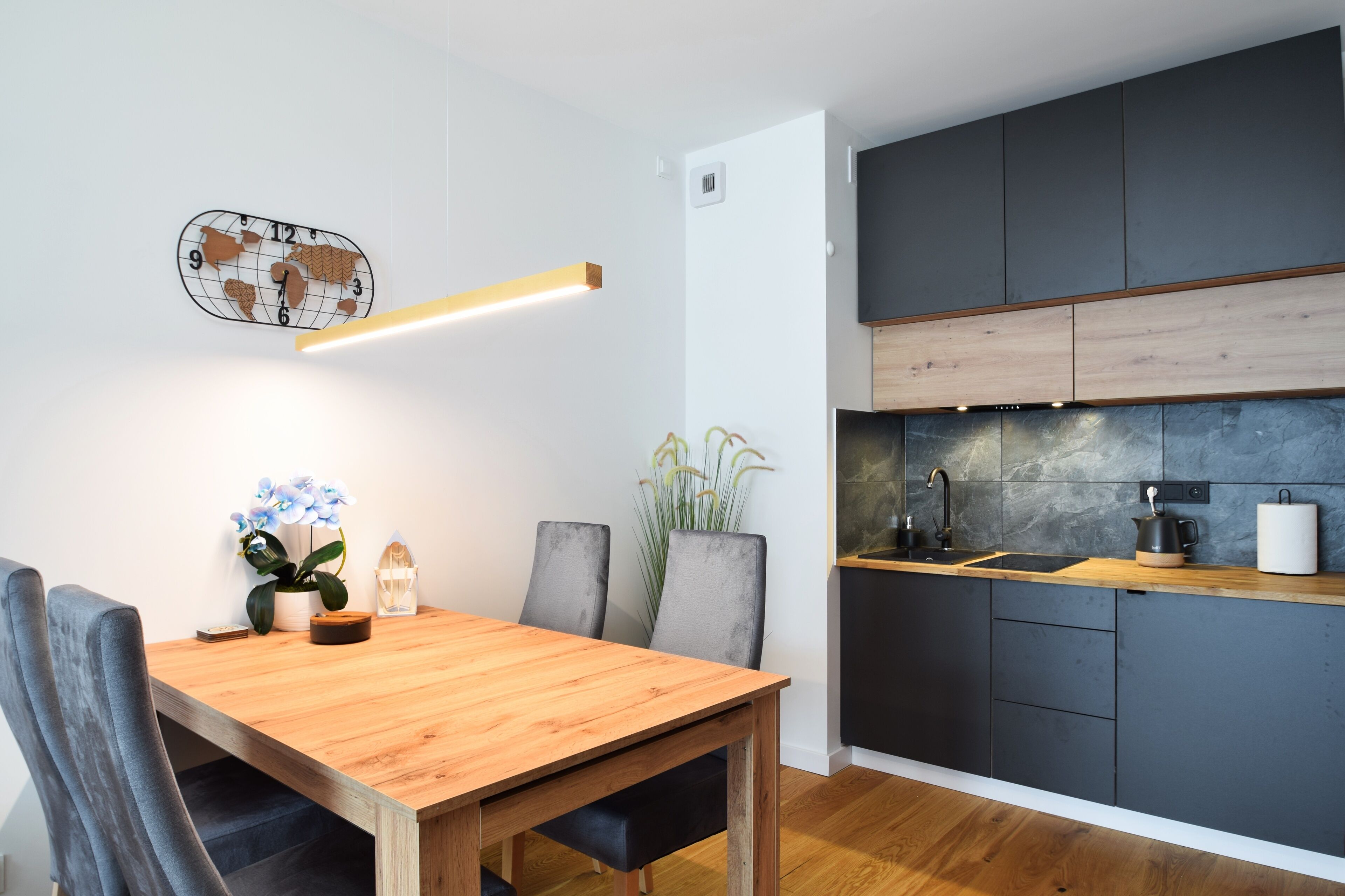 Een moderne keuken met donkere kastjes, een houten aanrechtblad en een ingebouwde kookplaat.