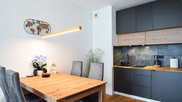 Een moderne keuken met donkere kastjes, een houten aanrechtblad en een ingebouwde kookplaat.