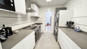 A modern kitchen with a built-in oven, a kettle, and a sink. - PUSHE Playa Granada Beach & Golf 12 (Motril)