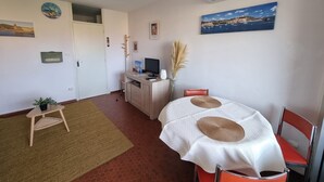 Una habitación con cama, escritorio, silla y aire acondicionado.