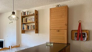 Eine Küche mit einem Holzschrank, einem Bücherregal und einem Retro-Radio an der Wand.