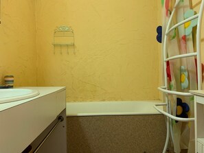 A bathroom with a bathtub, a toilet, and a sink.