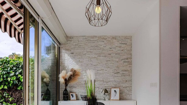 A modern dining area with a white table, four chairs, and a hanging light fixture. - Marina Rey – 400m from beach, Côte d’Azur vibe (Villeneuve-Loubet)