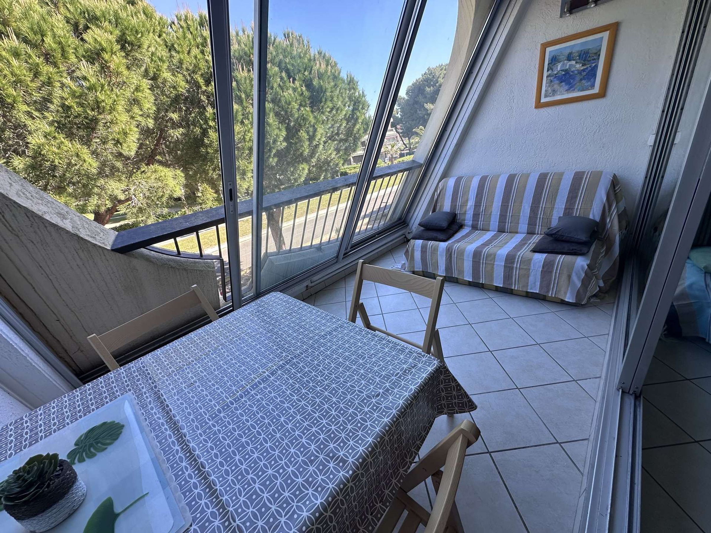 A balcony with a table, chairs, and a sofa.