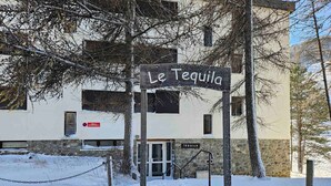 A sign reading "Le Tequila" in front of a building with a stone facade and a door marked "TEQUILA".