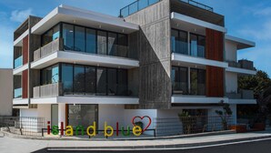 Un immeuble moderne à plusieurs étages, doté de grandes fenêtres et d’un toit plat.