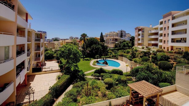 A residential building with a swimming pool surrounded by greenery. - Vacation Apartment In Portimao (Portimão)