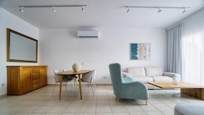 Un salon moderne avec une table à manger, un canapé et un fauteuil.