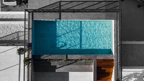 Vue aérienne d’une piscine rectangulaire, avec une zone de terrasse en bois attenante.