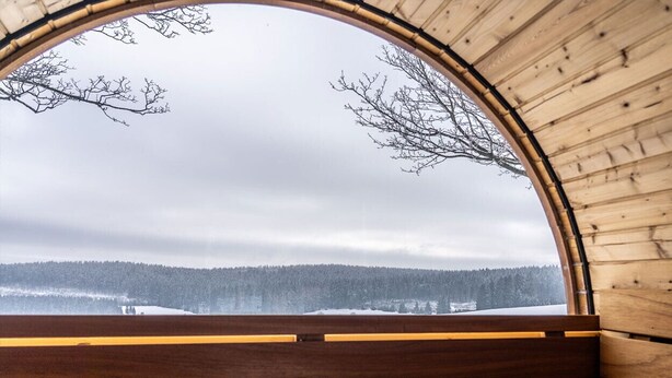 A wooden cabin with a large arched window overlooking a snowy landscape. - Haus Abendrot (Sayda)