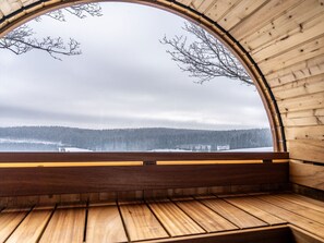A wooden cabin with a large arched window overlooking a snowy landscape. - Haus Abendrot (Sayda)