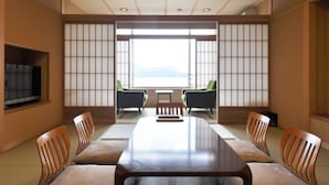A traditional Japanese-style room with tatami flooring, a low table, and sliding doors. - Miyahama Grand Hotel (Hatsukaichi)