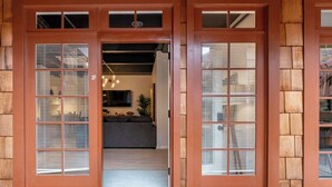 A wooden door with a 'hello' mat, leading to a room with a sofa and a TV. - Gorgeous Villa Steps to La Jolla Cove (San Diego)