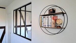 Un passadís amb un gran finestral i una biblioteca circular amb llibres i un glob.