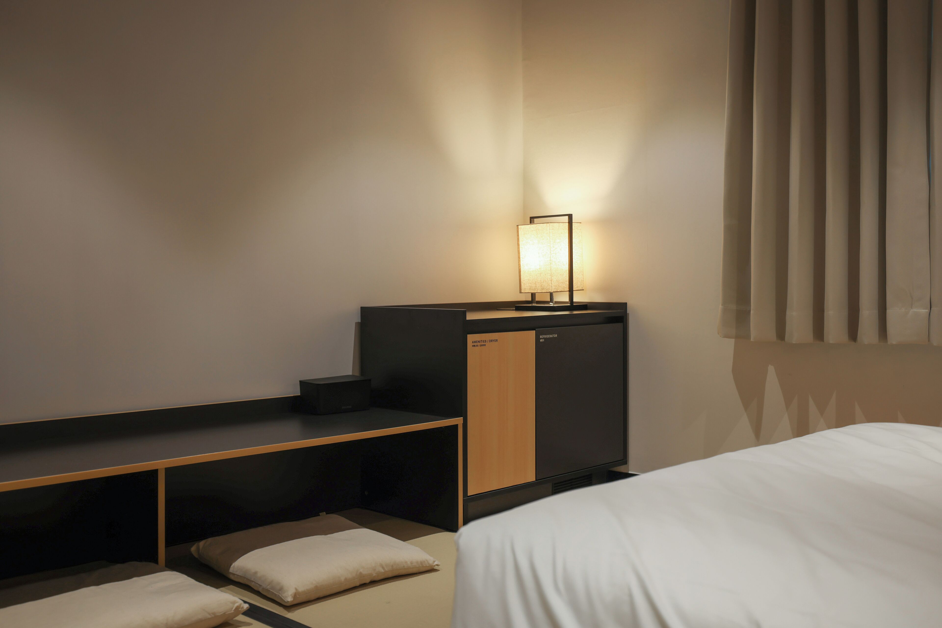 Una camera d'albergo con un letto, una scrivania e una lampada.