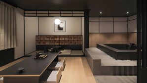 A modern interior with a long dining table, cushioned seating, a wall-mounted picture frame, and a built-in bathtub. - Mitasuya Ryokan Hotel Gumi Wonpyeong Branch (Gumi)