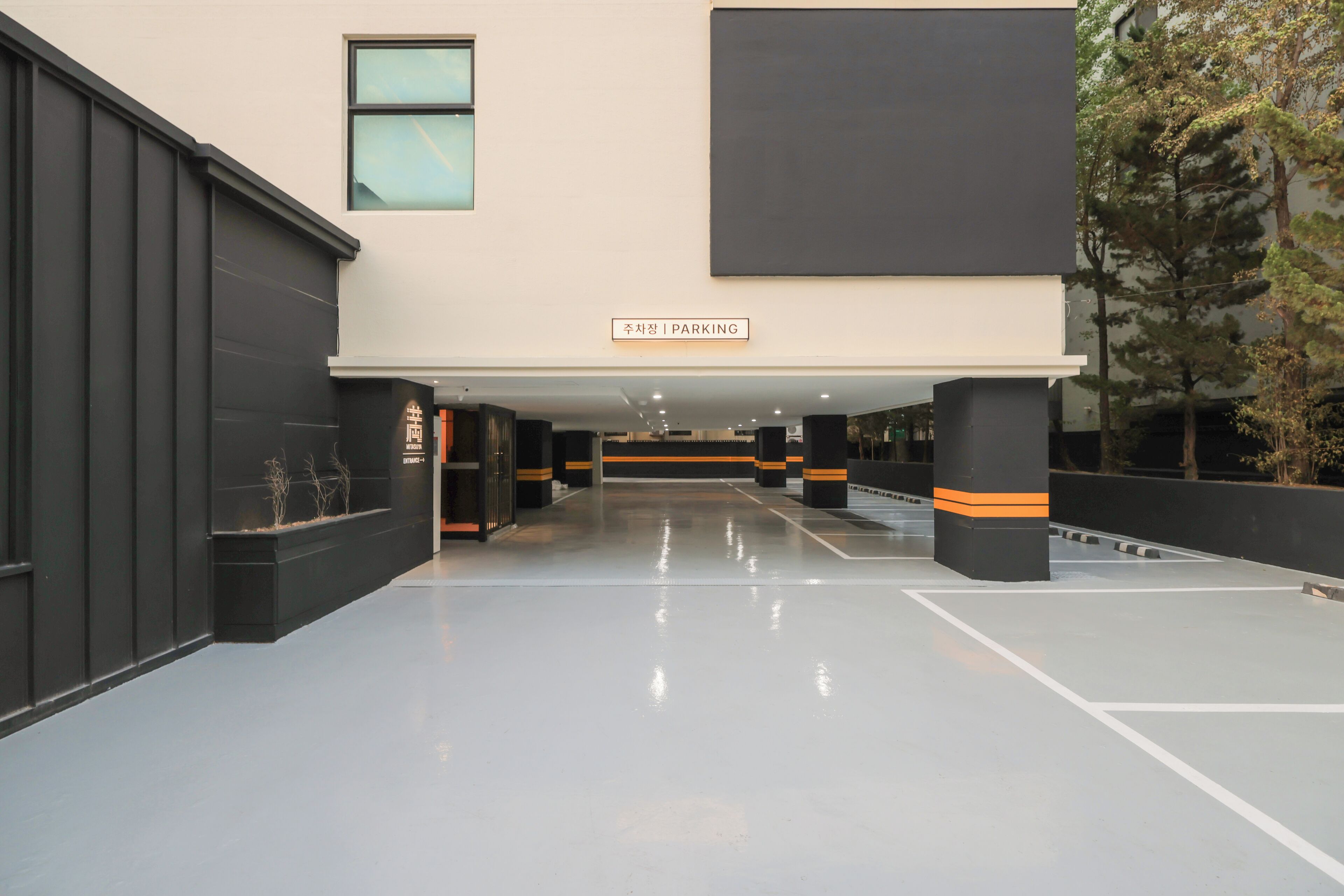 A modern building with a sign indicating a parking area.