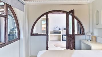 Una camera da letto con un letto grande, una toeletta con specchio e vista all'esterno.