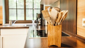 A kitchen with a wooden utensil holder on the counter.