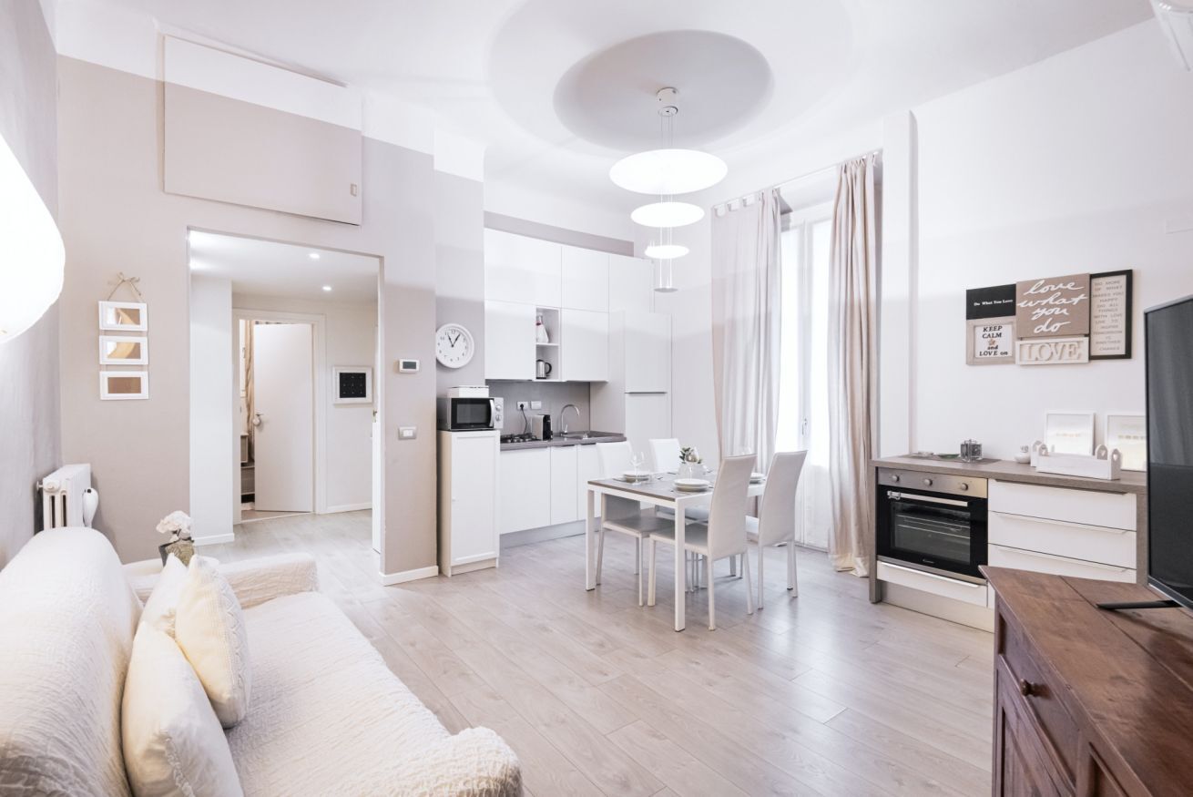 Un salon moderne comprenant un canapé, un coin repas et une cuisine.