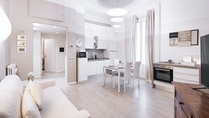 Ein modernes Wohnzimmer mit Sofa, Essbereich und Küche.