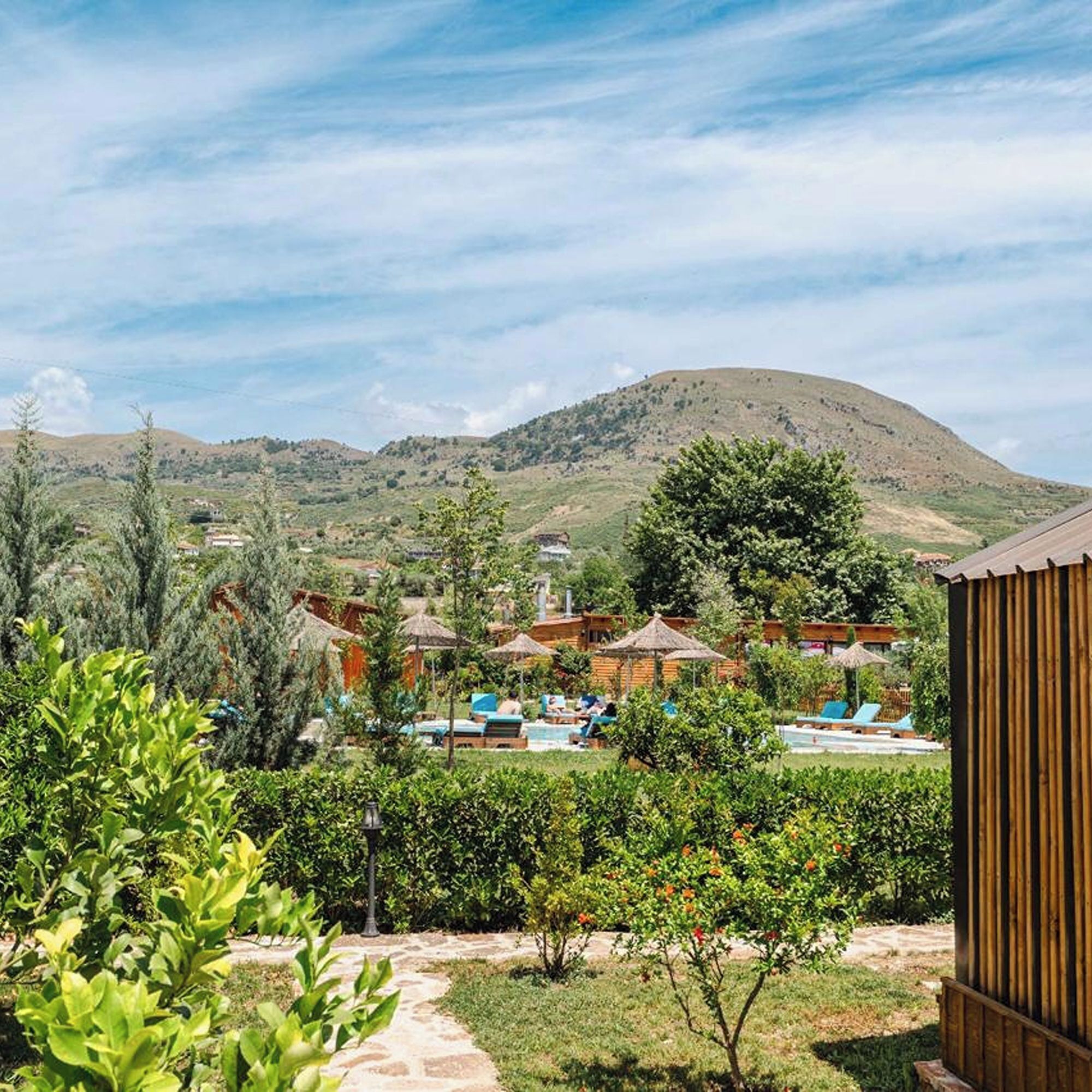A resort with outdoor pools, guest rooms, and a mountainous backdrop.