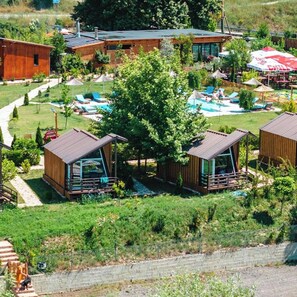 A residential area with two wooden cabins, a swimming pool, and a barbecue area. - Mesopotam Agrotourism Resort (Mesopotam)