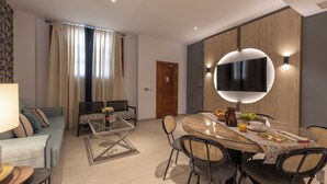 Una sala de estar moderna con un sofá, una mesa de centro y un comedor con una mesa redonda y sillas.
