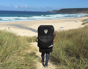 A person walking on a sandy path towards a beach with grass on either side. - Eco-friendly Cornish Sanctuary Peaceful Location (Penzance)