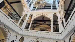 A multi-level atrium with ornate white arches and a central chandelier.