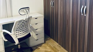 A room with a white desk, a white office chair, and a wooden wardrobe with two doors. - Cozy amazing one bedroom unit Mariam  (Kampala)