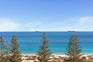 A coastal landscape with a clear view of the ocean, sandy beach, and several ships in the distance. - Apartment R311 - smart, stylish apartment in resort complex (Scarborough)