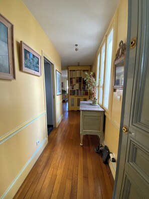 Stunning hallway with a door, potted plant, and framed artwork.