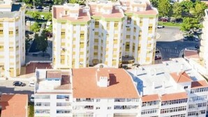 Un paysage urbain côtier avec de hauts immeubles, une plage et une vue dégagée sur l’océan.