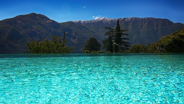 Une piscine d’eau cristalline, avec une chaîne de montagnes en toile de fond.